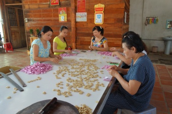 Ladies making and wrapping coconut candy by hand